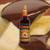 Bottle of Coruba Dark Jamaican Rum over backdrop of chocolate covered pineapple.