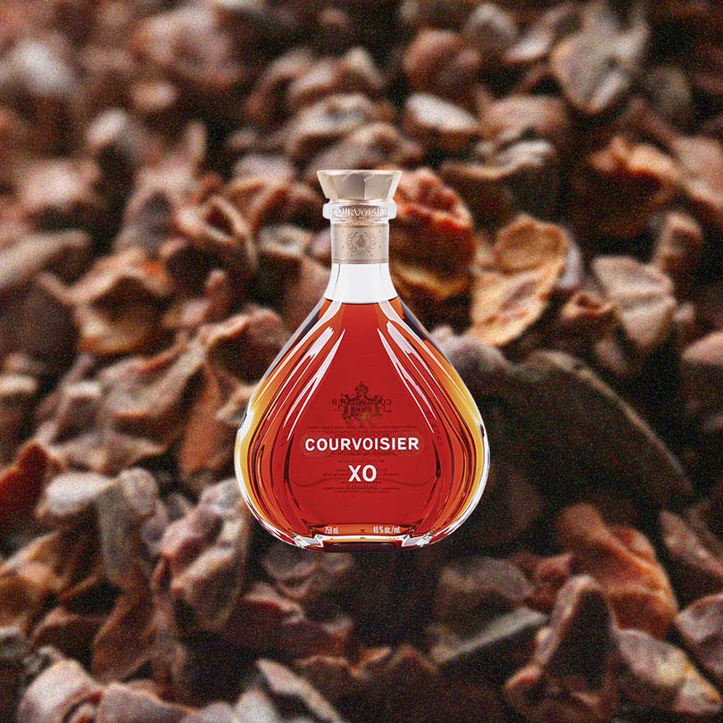 Bottle of Courvoisier XO Cognac over unidentifiable backdrop image.