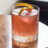Sazerac cocktail sitting on a table in the sunlight.