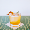 Photograph of a Oaxaca Old Fashioned cocktail on a table in the style of a contemporary cocktail recipe book.