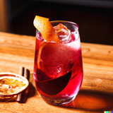 A "Sicilian Spritz" with Amaro Averna on a wooden table in the style of a contemporary cocktail recipe book.