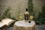 Bottle of The Lost Explorer Reposado Tequila on a stone table with 2 sipping glasses and a book nearby. 