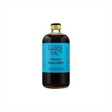 A large bottle of dark syrup with a canary blue label that reads: Liber & Co Demerara Gum Syrup.