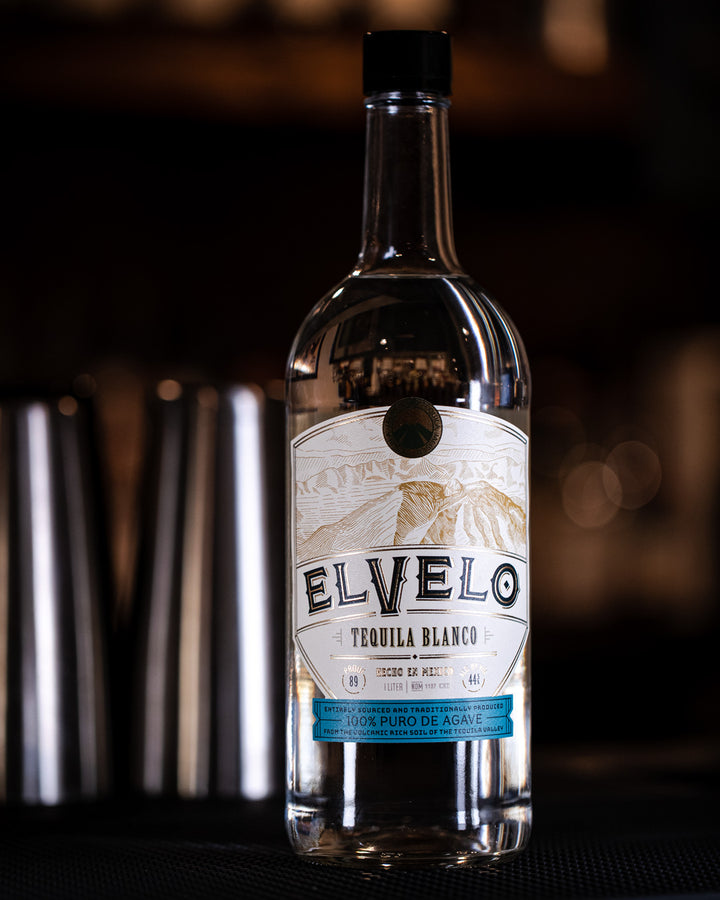 Elvelo Tequila Blanco bottle with a blurred bar background