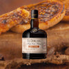 Bottle of El Dorado High Ester Blend LBI DHE Rum over backdrop image of baked goods.