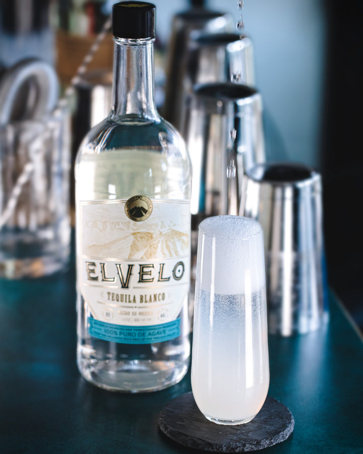 Elvelo tequila bottle with a glass of margarita on a bar counter