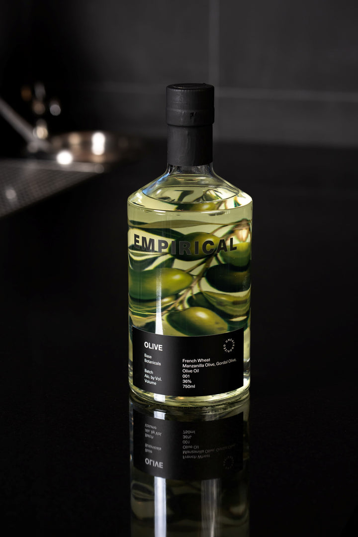 Bottle of Empirical Olive liqueur on a dark surface