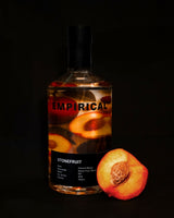 Bottle of Empirical Stonefruit wine with a stone fruit on a black background