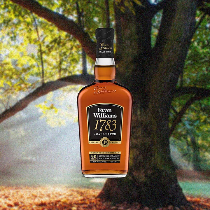 Bottle of Evan Williams 1783 Small Batch Bourbon over backdrop image of a tree in a forest on a sunny day.