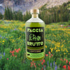 Bottle of Faccia Brutto Centerbe Herbal Liqueur over backdrop of flowers in a meadow.