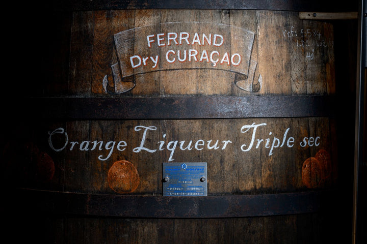 Wooden barrel with Ferrand Dry Curaçao branding and product details.