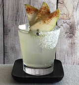 Cocktail with pear slices and cinnamon on a wooden surface