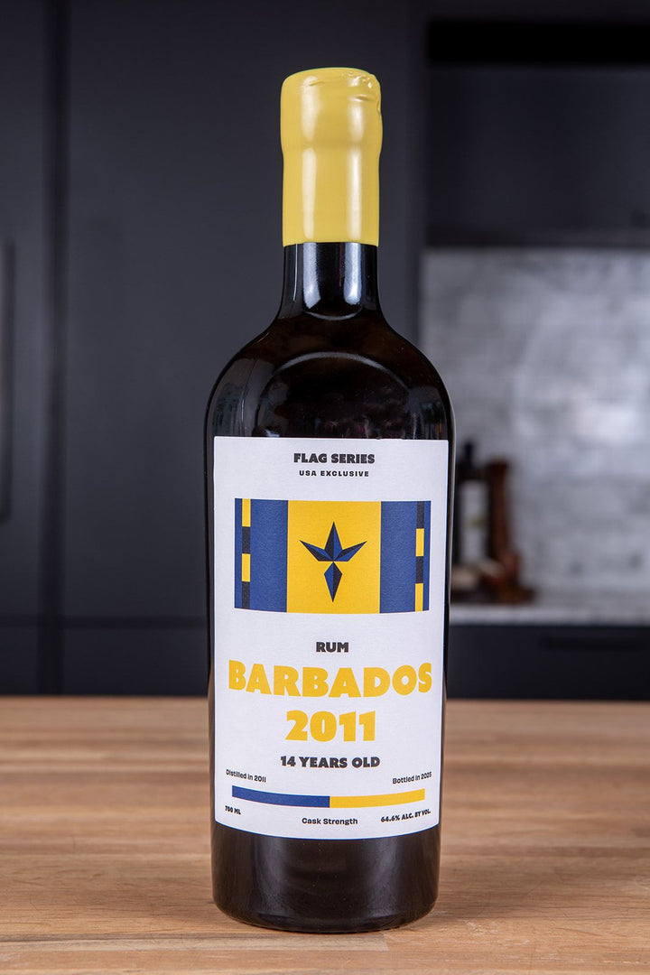 Bottle of Barbados rum with a yellow cap on a wooden surface