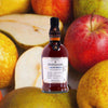 Bottle of Foursquare ECS Mark XXVI Magisterium over backdrop image of apples.