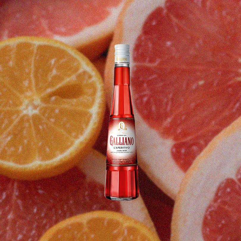 A bottle of Galliano L'Aperitivo against a backdrop of orange and grapefruit slices.