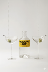 Bottle of Second Sip Gin next to 2 martinis with olive garnishes.