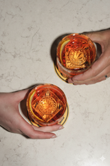 Two cocktails being picked up or set down on a table.