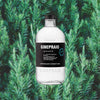 Bottle of Ginepraio Organic Amphora Navy Strength Gin over backdrop image of pine branches.