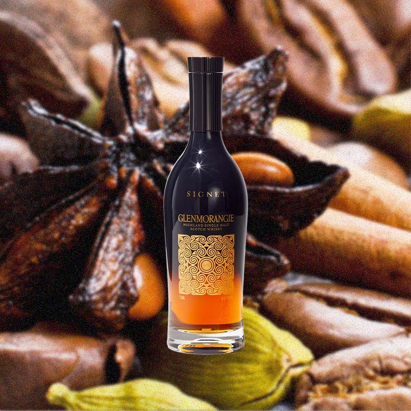 Bottle of Glenmorangie Signet Single Malt Scotch Whisky over backdrop of spices.