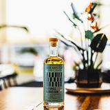 Bottle of Holmes Cay Single Barrel Rum on a wooden surface with a blurred background