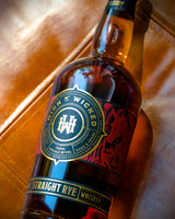 Bottle of High N' Wicked Straight Rye Whiskey on a leather surface