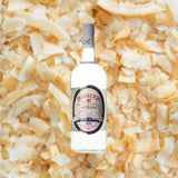 Bottle of Hamilton 87 White Stache Rum over back drop image of coconut bits.