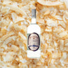 Bottle of Hamilton 87 White Stache Rum over back drop image of coconut bits.