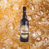 Bottle of Hamilton Jamaican Pot Still Black Rum over backdrop image of top soda or beer bubbles up close.