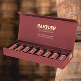 The Hampden Estate Jamaican Rum The 8 Marks Collection Aged 1 Year Set over back drop image of barrels.