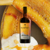 Bottle of The Hampden whisky with a pineapple and white sauce in the background