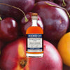 Bottle of Holmes Cay Barbados 2012 Port Cask Rum over back drop image of cherries.