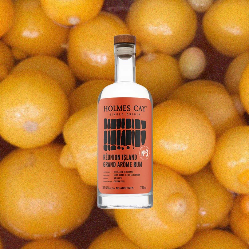Bottle of Holmes Cay Reunion Island Grand Arome over backdrop image of oranges.