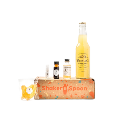 A brown Shaker & Spoon box with bottles containing the ingredients of the Horsefeather Cocktail Kit. product image