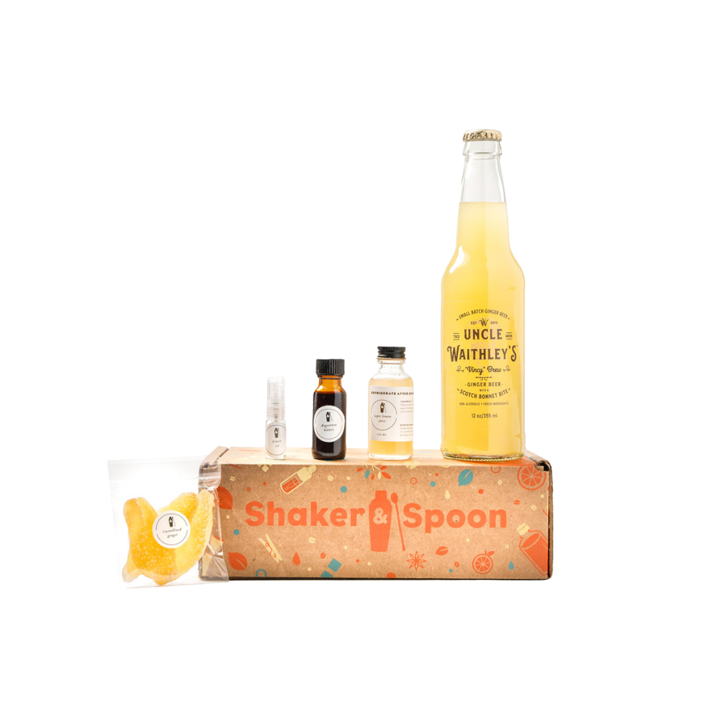 Brown Shaker & Spoon box with small bottles containing the ingredients to make a cocktail.