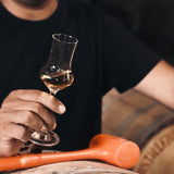 Person holding a glass of whiskey with a blurred background