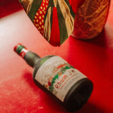 Bottle of Rhum JP on a red surface with a decorative item in the background