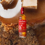 Bottle of J.P. Wiser's 10 Year Old Whisky over back drop image of baked goods, close up.