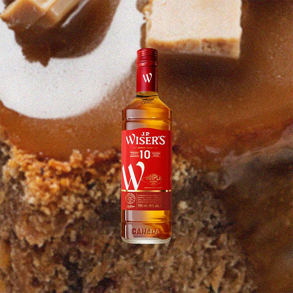 Bottle of J.P. Wiser's 10 Year Old Whisky over back drop image of baked goods, close up.