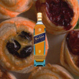 Bottle of Johnnie Walker Blue Label over backdrop image of pastries.