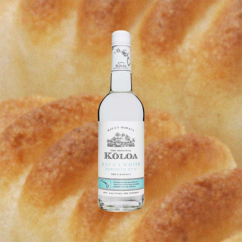 Bottle of Kōloa Kaua'i White Hawaiian Rum over backdrop of baked bread.