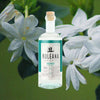 A bottle of Kuleana Rum Works Huihui Rum set against a backdrop of fragrant jasmine flowers.