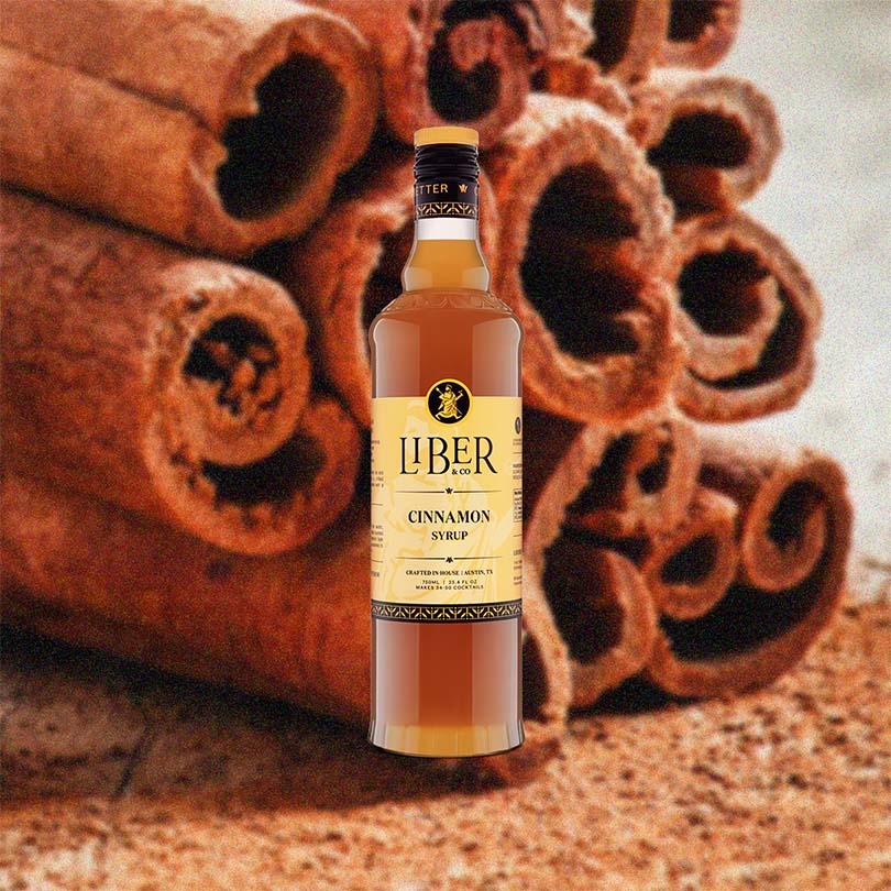 Bottle of Liber Cinnamon Syrup with cinnamon sticks in the background