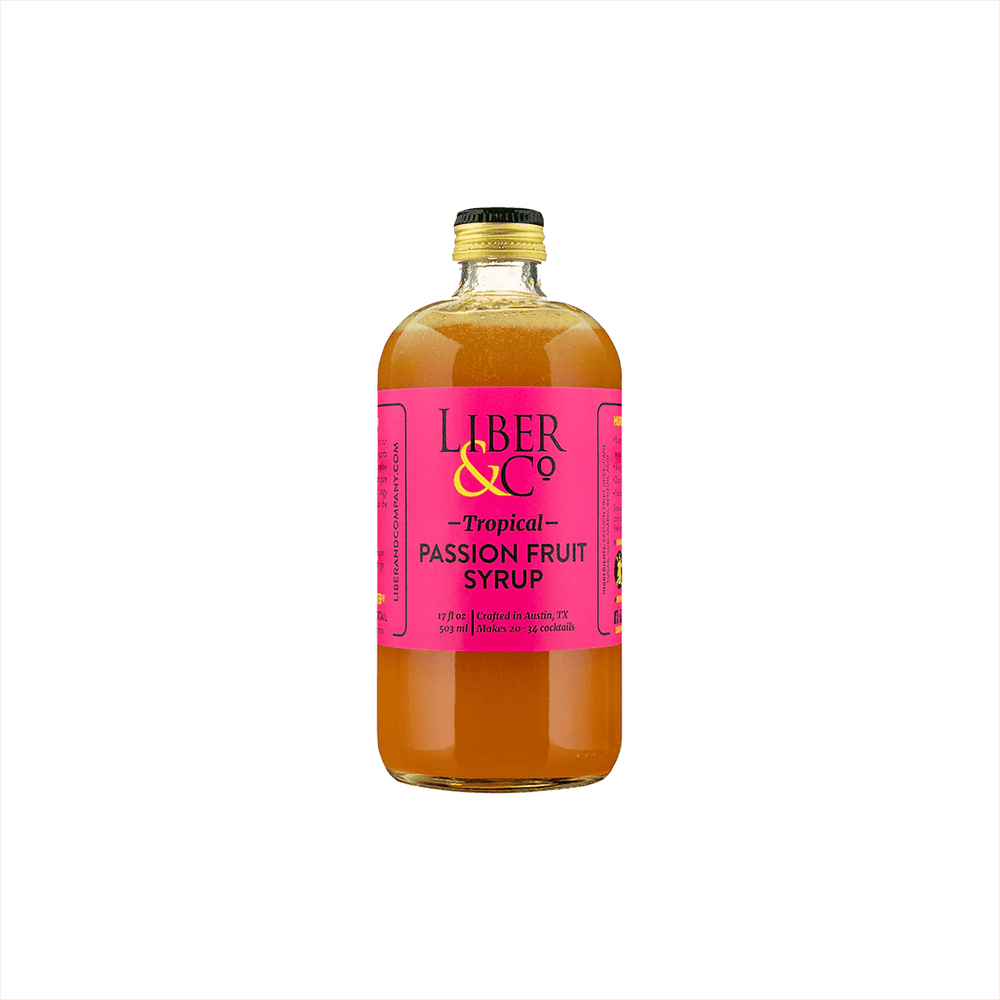 A large bottle of rich looking orange syrup with a fuschia label that reads: Liber & Co Tropical Passion Fruit Syrup.