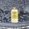 Bottle of Liber & Co. Premium Tonic Syrup over backdrop of water droplets.