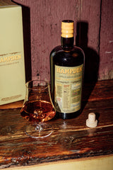 Hampden bottle and glass of rum on a wooden surface