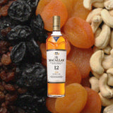 Bottle of Macallan 12 Year Old Double Cask Single Malt Scotch Whisky over back drop image of cashews and dried fruits.