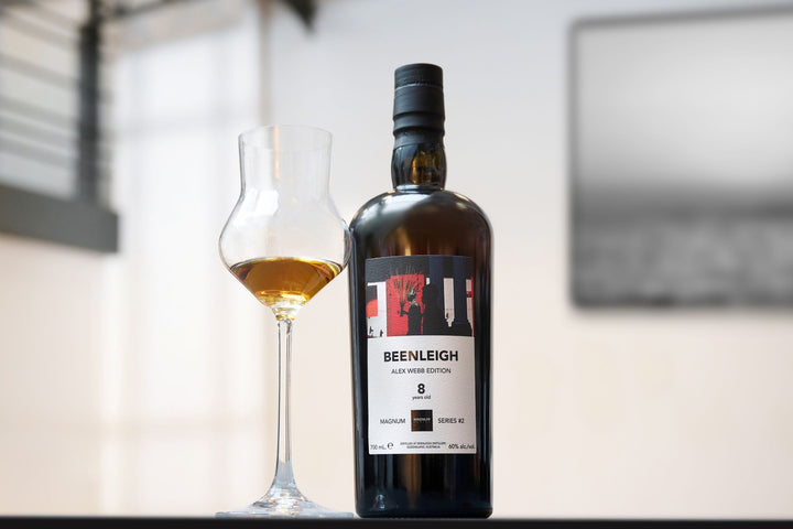 Bottle of Beenleigh whisky with a glass on a reflective surface