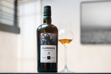 Clarendon whiskey bottle with a glass of whiskey on a blurred background