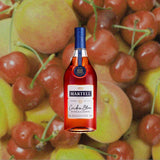 Bottle of Martell Cordon Bleu Cognac over backdrop image of fruit.