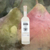 A bottle of Mezcal Union El Viejo against a backdrop of pears with smoke swirling about them.